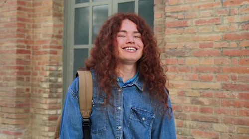 Smiling young woman with red curly hair