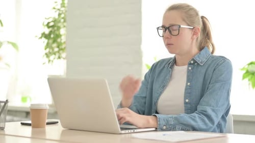 Woman Coughing While Using Laptop Indoors