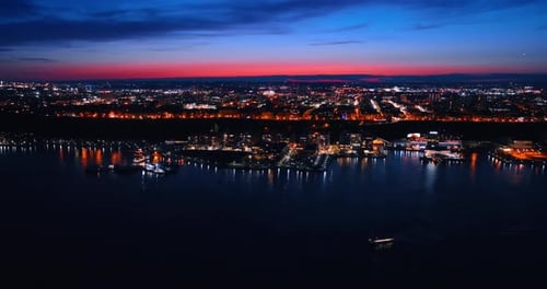 Voando sobre o East River, aproximando-se da luminosa orla marítima da metrópole