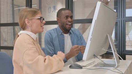 Excited Colleagues Celebrate Success Together in Office