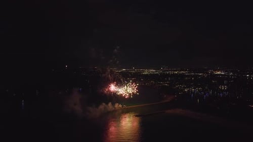 Vista aérea de fogos de artifício brilhantes explodindo com luzes coloridas sobre a costa do mar no Dia da Independência dos EUA