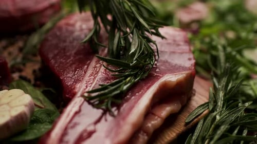 Rosemary Twig Brushing Olive Oil on Beef Steak Close Up