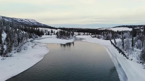 Flug über den Fluss mit verschneiter Landschaft im Winter in Yukon, Kanada. - Luftaufnahme