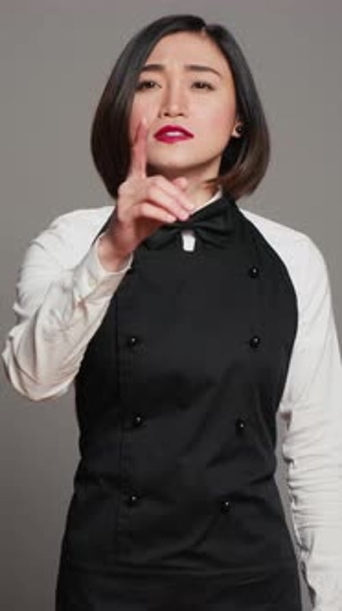 Vertical Video Restaurant Hostess Showing Silence Symbol in Studio