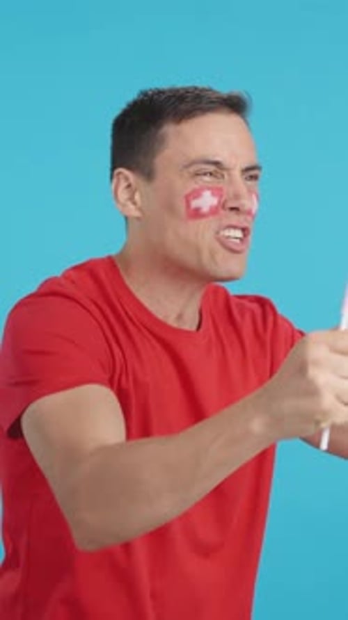 Man Celebrates with Flag and Face Paint