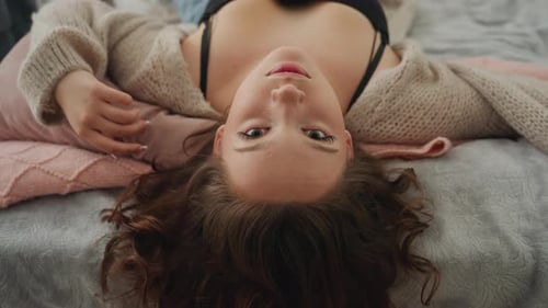 Young Woman Lying on Bed in Casual Setting