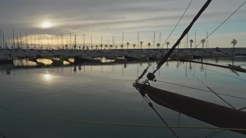 los barcos atracados se mueven en aguas tranquilas mientras el sol de la hora dorada se refleja en el mar tranquilo