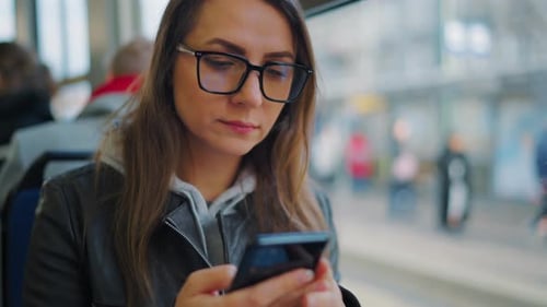 Mulher de transporte público em bonde usando smartphone
