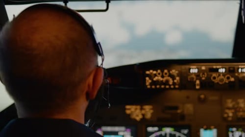Male Aviator Using Handle and Windscreen in Cockpit to Fly Airplane
