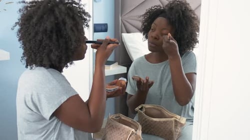 African Woman Applying Makeup Base Using Makeup Brush