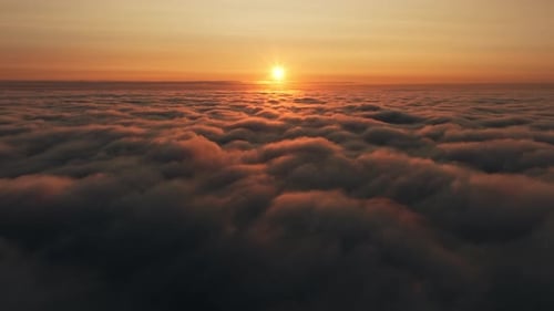 Scenic Aerial View Above the Clouds with Sun Rising at Dawn