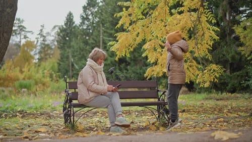 Woman and Child Enjoying Autumn Day in Park