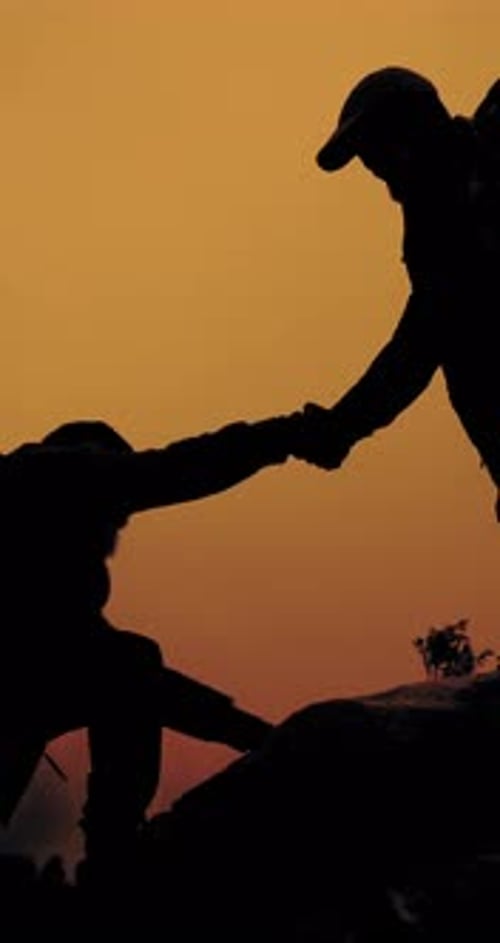 People, hiking and silhouette with helping hand on mountain for climbing or adventure together