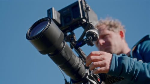 Professional Camera with Man Adjusting Lens