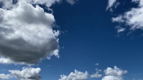 Cumulus clouds against a bright blue sky. Timelapse. August 2020
