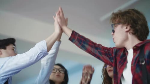 Team von jungen Profis, die ein Gruppen-High-Five abklatschen