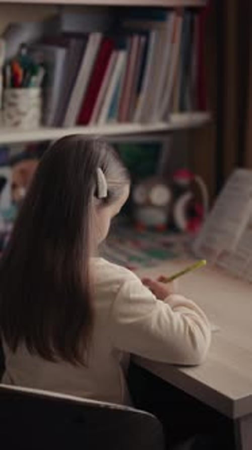 Girl Studying and Writing at Desk Indoors
