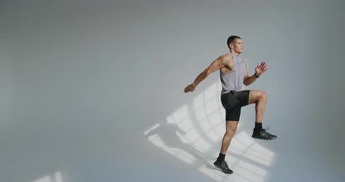 Athletic Young Man Performing Jump Training in a Studio