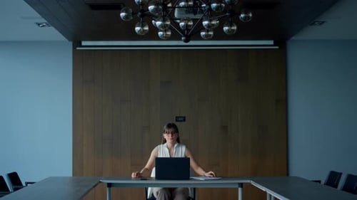Successful ceo looks at computer in conference hall solving problem at workplace