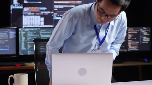 Programmeur entrant dans l'espace de travail pour écrire du code sur un ordinateur portable utilisant plusieurs moniteurs