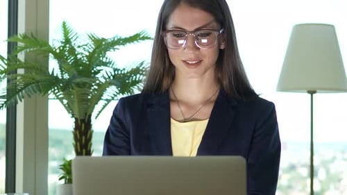 Woman Working on Laptop in Modern Office