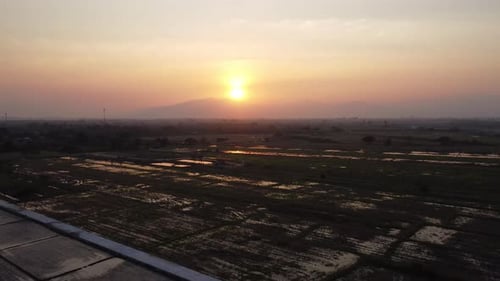 Aerial view of farmland with golden sunlight at sunrise in spring.