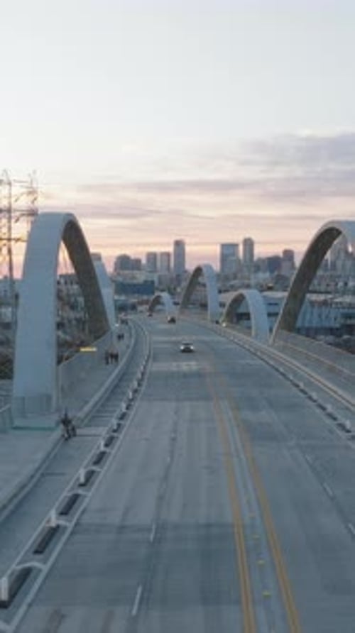 Low Traffic on New Modern Road Bridge with Concrete Arches High Rise Downtown Buildings Against