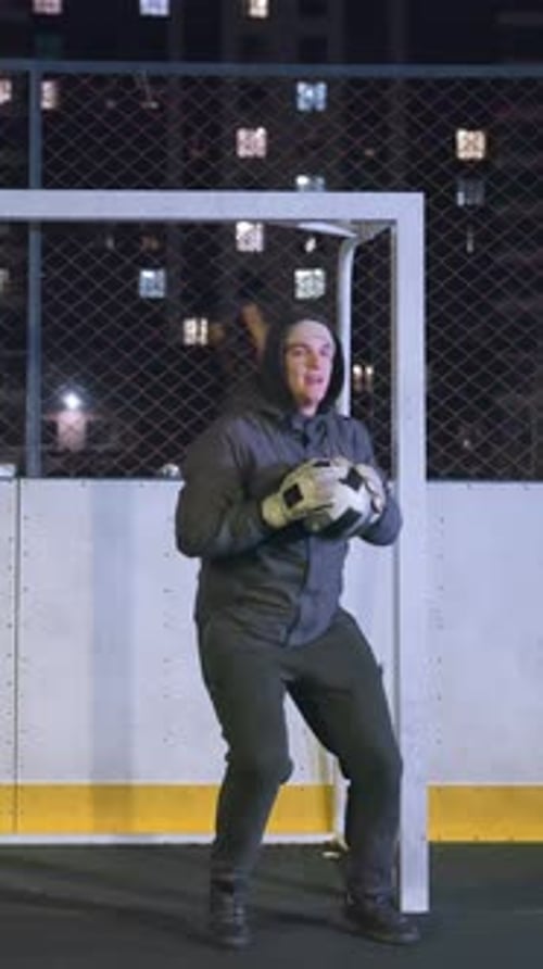 Young Adult Goalie Practices Soccer at Night