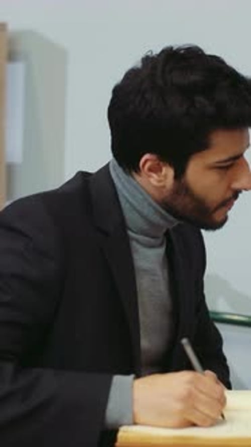 A Suited Man Explores Creativity Crafting Leather and Jotting Ideas