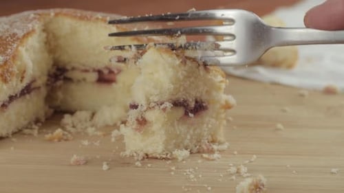 Eating slice of Victoria sponge cake with fork close up shot