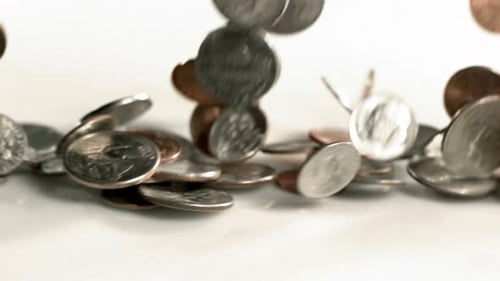 Slow motion rainy day of us pennies and dollars falling for retirement savings