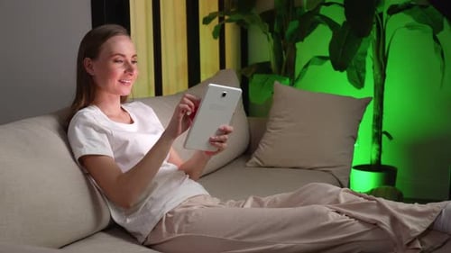 Woman Relaxing at Home with Tablet Device