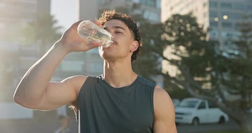 Man, fitness and drinking with water in city for workout break, hydration or recovery