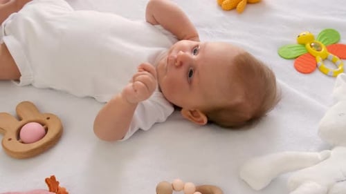 The Baby is Lying on the Bed Playing Selective Focus
