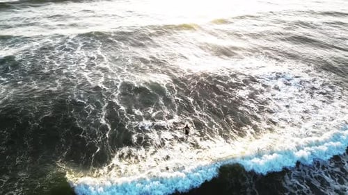 Surfer rides undulating waves, determined to overcome the ocean’s obstacles