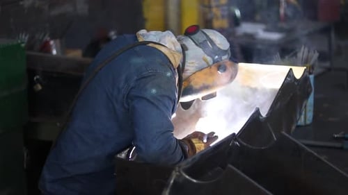 Welder Working on Metal in Factory Environment