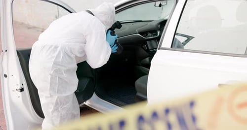 Forensic Scientist Photographs Interior of Car at Crime Scene