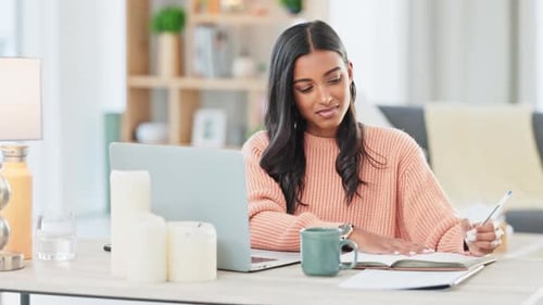 Stressed student studying on laptop, writing notes in book and elearning