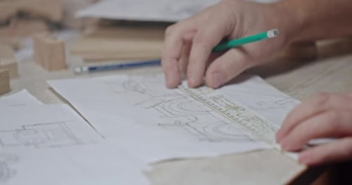Hands Drawing Architectural Sketch with Ruler and Pencil