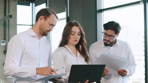 Team Members Collaborating on Project Tasks in a Modern Office Setting During the Day Utilizing