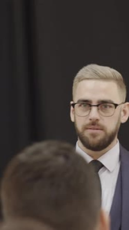 Man in Suit Presents at a Meeting