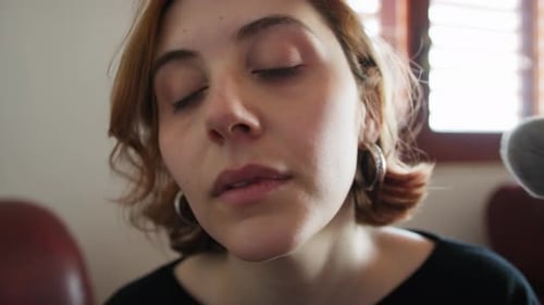 Young Woman Applying Makeup with Brush Indoors