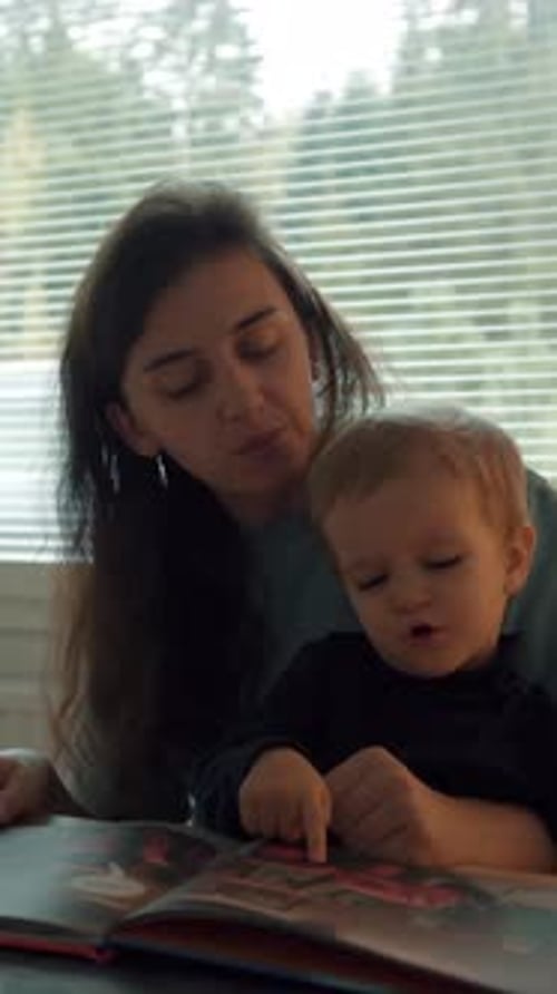 Woman Reads a Book with Infant