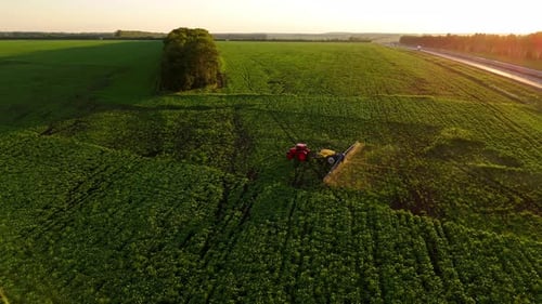 Aerial Shot of a Tractor Spraying an Agricultural Field with Pesticides