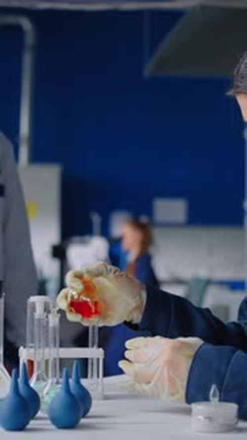 Scientist Carefully Mixes Red Liquid in Laboratory