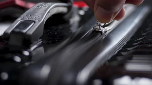 A man closes the zipper on a black suitcase.