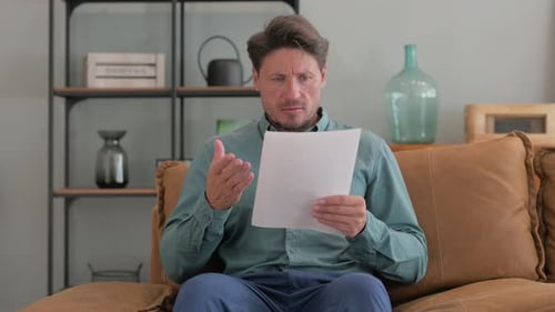 Man Reading Document, Expressing Frustration