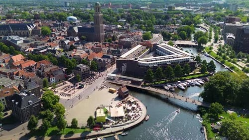 Aerial view of a historic European city with canals boats and a central square showcasing red-roofed