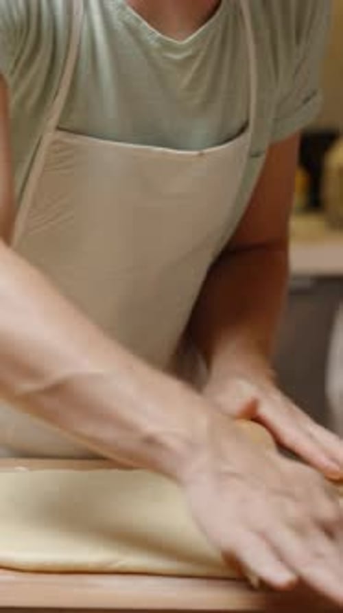 Dough Rolling on Cutting Board in Kitchen