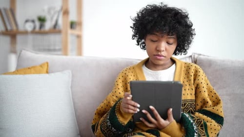 Young Adult Uses Tablet in Home Interior
